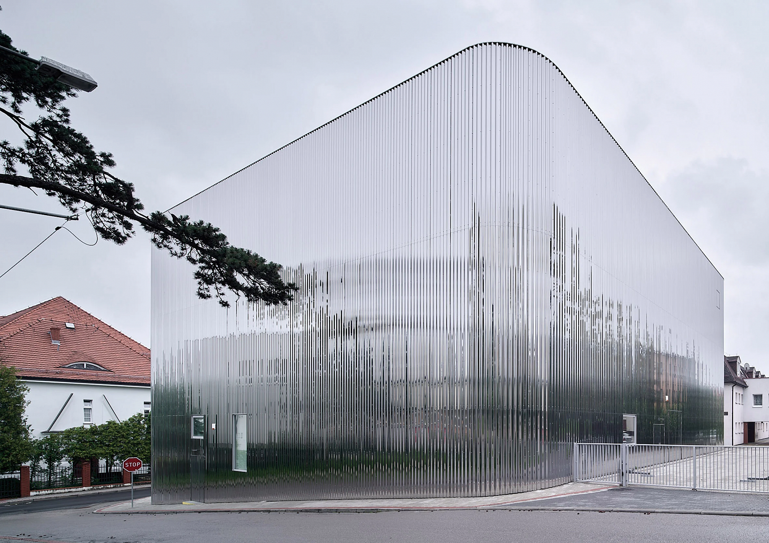 SLAS Architekci окутывает польский концертный зал зеркальным стальным фасадом